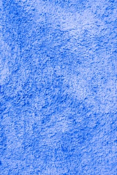 Vertical photo of faded blue plaster with white spots. Abandoned wall.