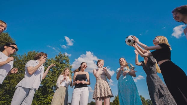Friends tossing a ball in a meadow on a summer day
