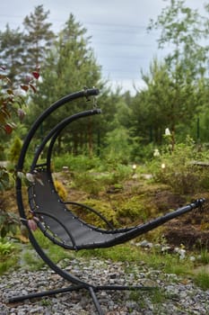 A beautifully crafted modern wicker hammock chair nestled in a serene garden setting, ideal for ultimate relaxation