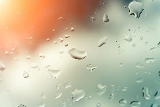 Raindrops on glass against blue sky. Window view background screensaver. Place for text banner.