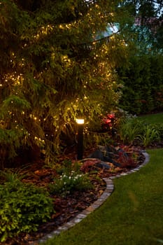 A beautifully peaceful garden pathway, softly illuminated by sparkling twinkling lights, nestled amid lush greenery