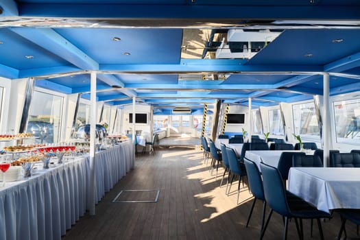 The boats elegant interior with tables and a stunning view is perfect for dining or hosting events