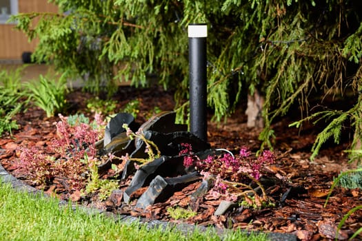 An elegantly designed garden setup that showcases vibrant plants along with a distinctive black decorative feature