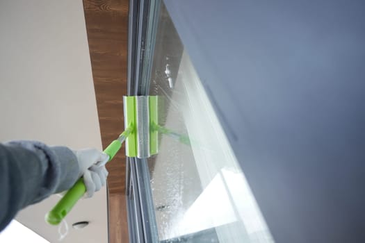 Rubber squeegee cleans a soaped window