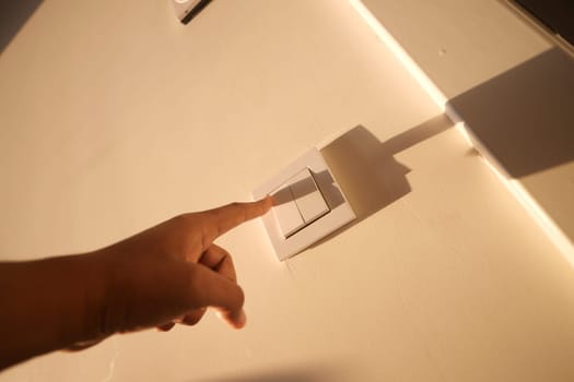 A finger turning on lighting switch