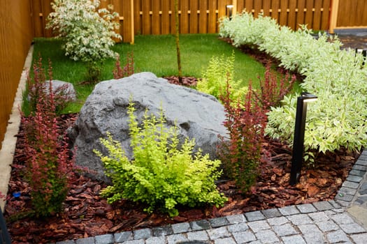 A lively garden with beautiful rocks, lush greenery, and colorful shrubs, creating a serene space for relaxation