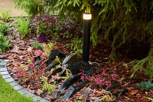 A beautifully landscaped garden, which features decorative lighting and a vibrant array of colorful flowers