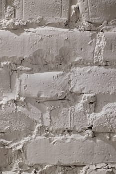 This is a detailed closeup image of a weathered white brick wall showcasing its subtle textures and unique patterns