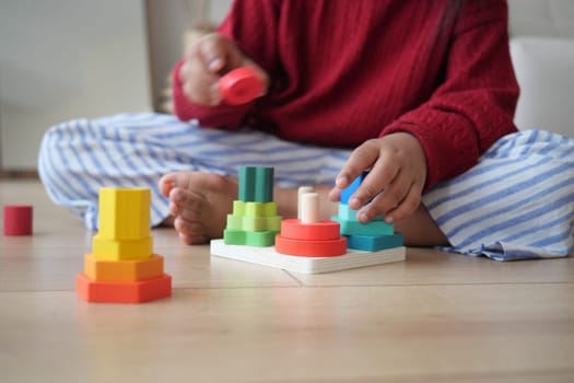 A child joyfully plays with colorful stacking toys that improve motor skills and coordination