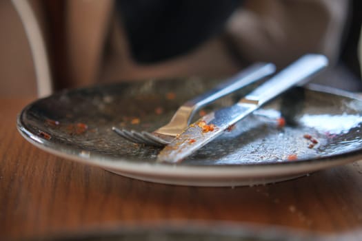 An empty dirty plate with a fork..