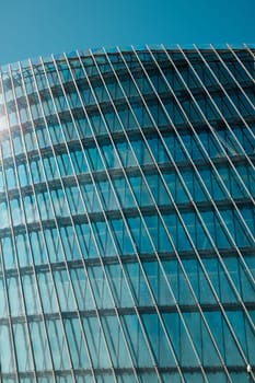 The sleek and modern architectural design prominently features reflective glass panels along with dynamic lines