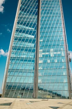 This stunning view of a sleek glass skyscraper showcases remarkable modern architectural design and elegance