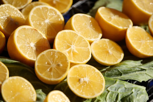 Bright lemon halves arranged on fresh green leaves, ideal for various dishes and drinks