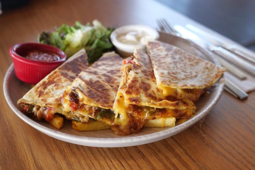 Enjoy the rich flavors of a quesadilla platter served with fresh salsa and greens
