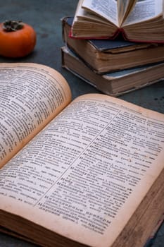 Close-up of several old dictionaries against a dark background. Selective focus.