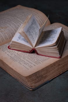 Close-up of two old dictionaries against a dark background. Selective focus.