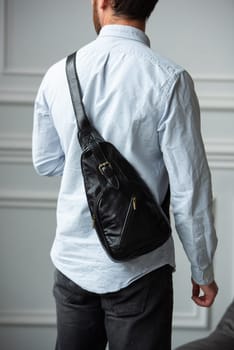 A man in a shirt with holding a black bag on his shoulder