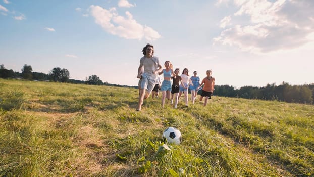 Graduates joyfully play soccer on a sunlit field, marking their accomplishments and looking forward to a bright future with friends