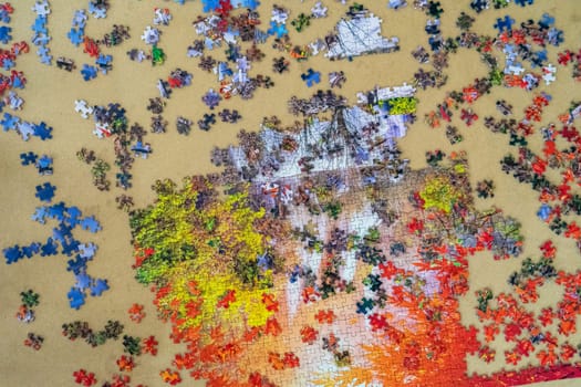 A background image of pile of mixed colorful jigsaw Puzzle pieces set scattered . Messy chaotic concept. Close up. Top view.