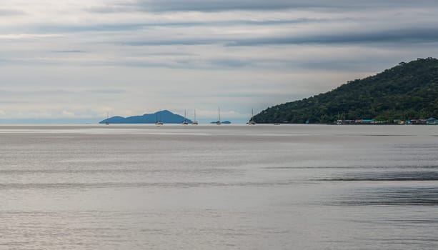 A breathtaking and serene coastal view featuring a picturesque island and dramatic clouds above calm, tranquil waters