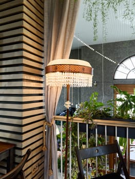 This chic floor lamp beautifully enhances and complements the lush greenery while adding charm to modern decor