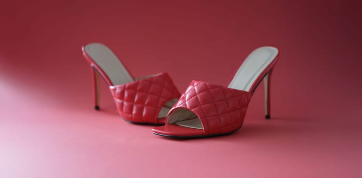 Pink slippers with heels on a pink background, close-up. Photo area for shooting shoes in the studio, shop window