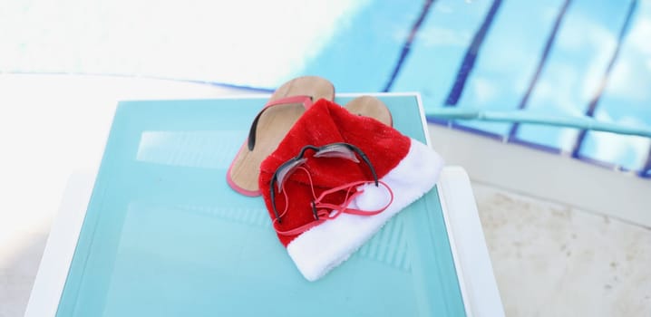 Santa Claus hat and accessories for swimming in the pool, close-up. New Year in warm countries, winter recreation on the water