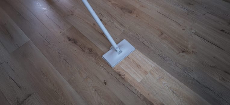 A washing vacuum cleaner washes the laminate, a clean footprint on the floor, close-up. Parquet cleaning equipment