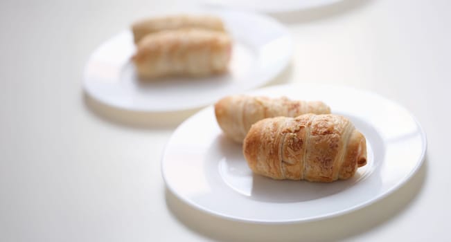 Delicious pigs in a blanket on a white plate, close-up. Mini crescent dogs. Two ingredients. Flaky, savory and perfectly dippable appetizers