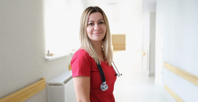 Beautiful female doctor smiling, clinic corridor. Portrait of a happy healthcare professional, ambulance