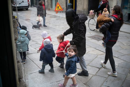 Cremona, Italy - November 20th 2024 Group of preschoolers walking on a rope held by their teacher in cremona, italy, showcasing a playful outdoor activity
