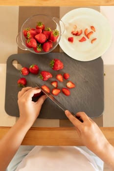 women's hands prepare strawberries for dessert.