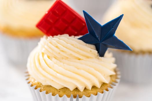 Lemon cupcakes with lemon buttercream frosting, and decorated with patriotic blue chocolate star and red mini chocolate.