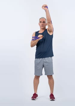 Full body length shot athletic and sporty senior man with fitness resistance band on isolated background. Healthy active physique and body care lifestyle after retirement. Clout