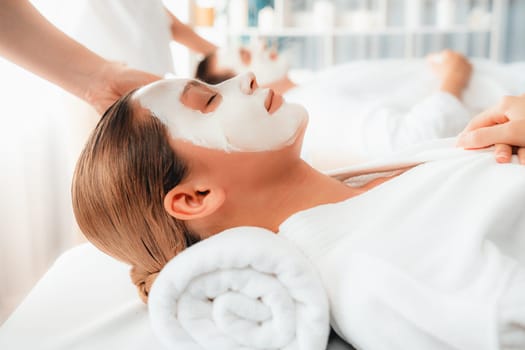 Serene ambiance of spa salon, couple indulges in rejuvenating with luxurious face cream massage with modern daylight. Facial skin treatment and beauty care concept. Quiescent