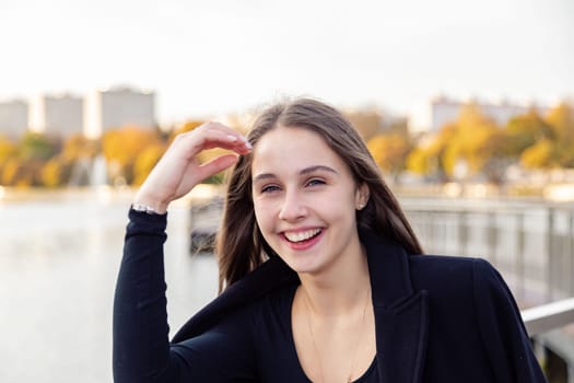 Portrait of a girl on a bridge near a pond in a city park