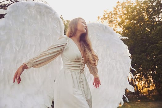 Beautiful girl dressed as an angel in the evening garden.