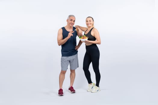 Happy smile senior man and woman portrait holding bowl of vegan fruit and vegetable on isolated background. Healthy senior couple with healthy vegetarian nutrition and body care lifestyle. Clout