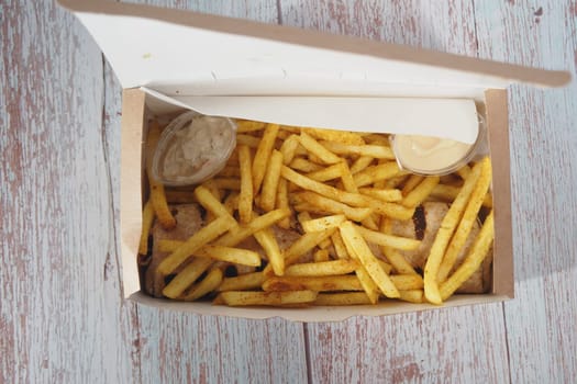 Delicious and crispy French fries served with a variety of sauces in a convenient takeout container