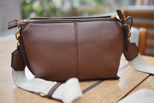 This chic and stylish brown leather handbag comes with a convenient detachable strap option