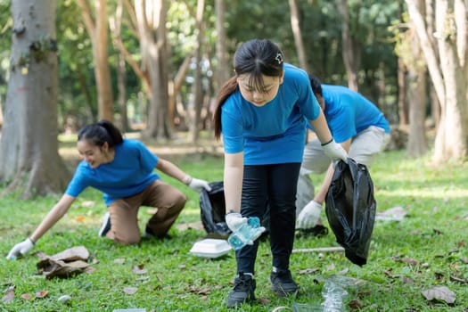 Family and volunteers actively collecting litter in a park, emphasizing teamwork and environmental care.