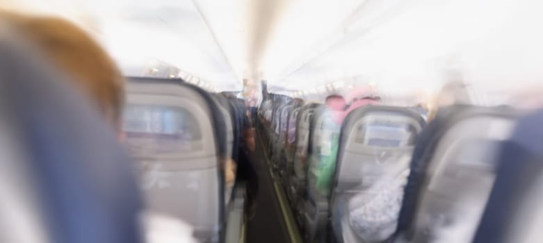 Comfortable passenger cabin of the aircraft, rear view, flashing. Fear of flight, aerophobia. Plane crash, blurred consciousness, blurry