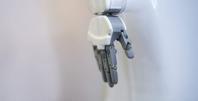 Robotic hand with fingers on a white background, close-up. Industrial manipulator, sensor, flexible simulator