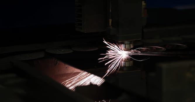 Bright sparks from metal turning, close-up. Laser cutting, mechanical engineering. Manufacturing complex parts