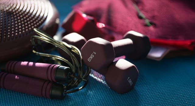 Dumbbells skipping rope set for fitness, close-up. Home workout program. Sports equipment for cardio exercise
