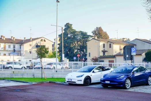 Cremona, Itally - October 6th 2024 Parked in a lot are white and blue tesla model 3 cars, featuring long range dual motor all-wheel drive