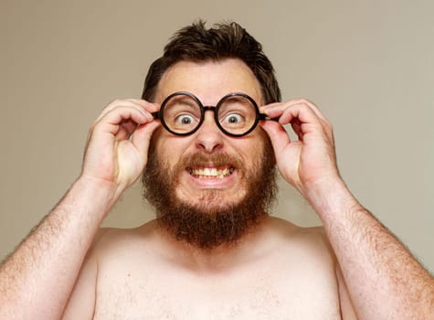 A man with glasses and a beard is wearing them and smiling. He looks like he is having a good time