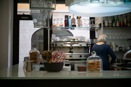 Cremona, Italy - November 20th 2024 Barista working behind the counter of a typical italian cafe in cremona, preparing coffee and serving customers