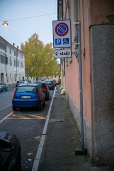 Lombardy, Italy - November 20th 2024 Blue citroen c3 pluriel parked near a sign indicating a reserved parking for disabled people in a residential street