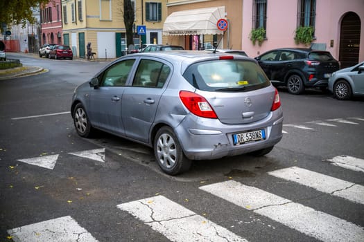 Lombardy, Italy - November 20th 2024 A slightly damaged silver opel corsa 1.3 cdti is parked on a pedestrian crossing in an urban environment